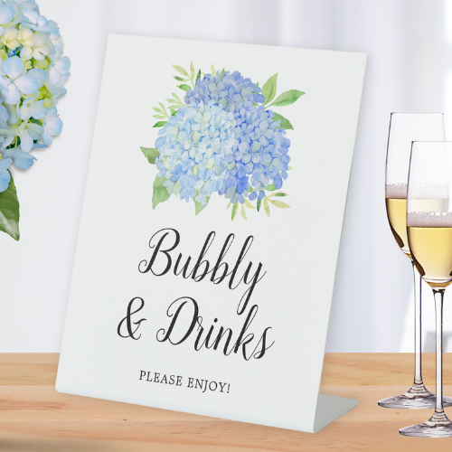 Bubbly and drinks bridal shower bar sign with blue hydrangea watercolor floral design and script typography.
