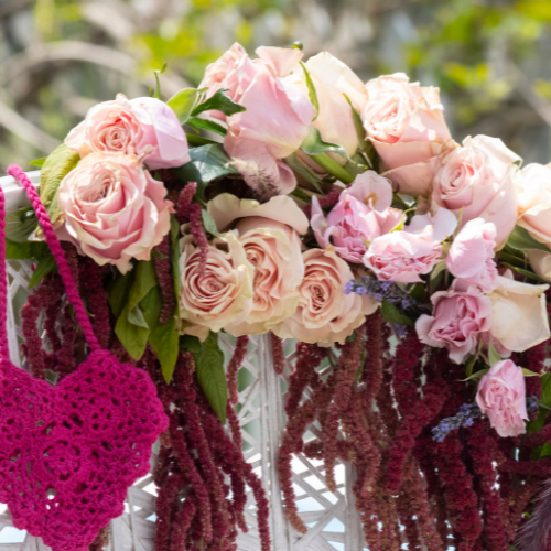 Coquette bridal shower theme inspiration image of vintage pink and blush ink roses with crochet heart decoration